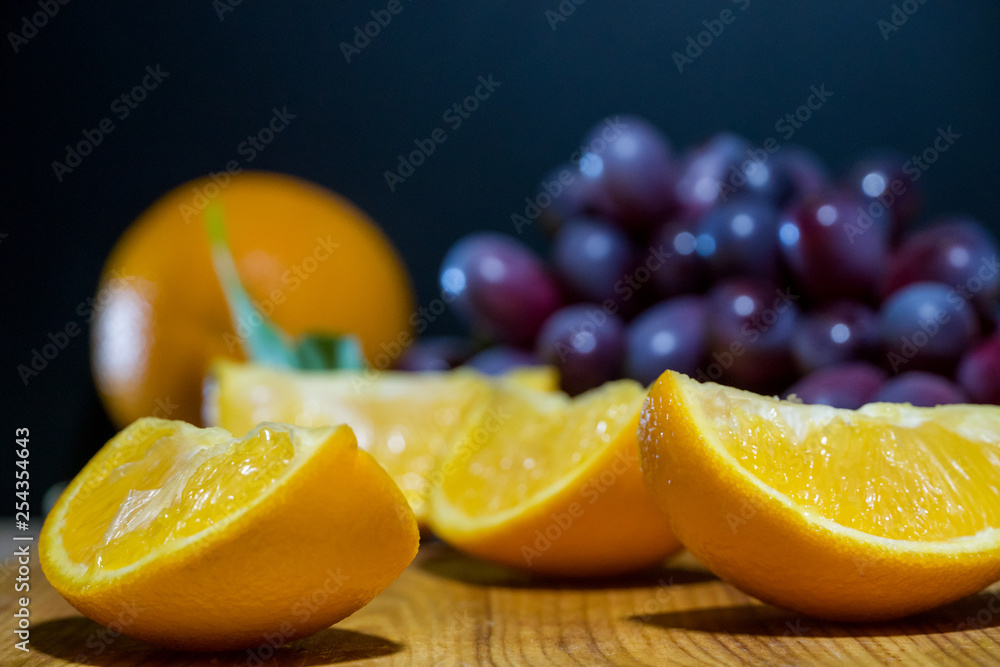 Orange slices and grapes on a wooden Board. Beautiful background of a set of fruits. Orange slices and grapes on a wooden Board. Beautiful background of a set of fruits.