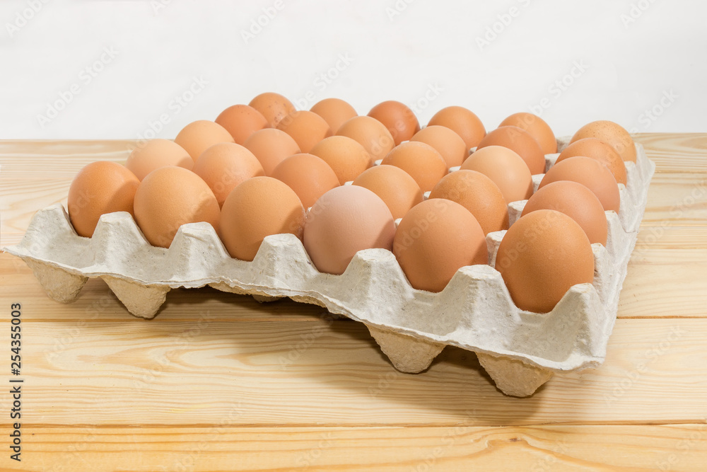 Brown eggs in egg tray on rustic table close-up Brown eggs in egg tray on rustic table close-up