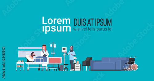 arab doctor and nurse visiting patient man lying bed intensive therapy ward healthcare concept hospital room modern medical clinic furniture copy space blue background horizontal