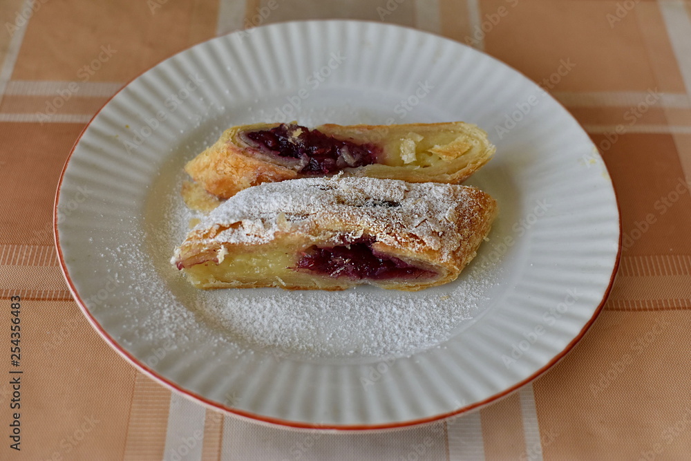 Two slices of tasty cherry strudel with vanilla cream on the plate Two slices of tasty cherry strudel with vanilla cream on the plate