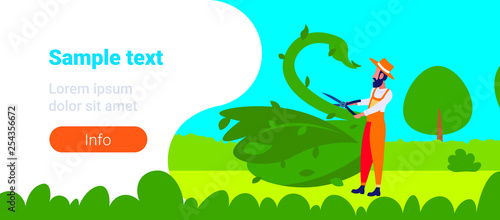bearded gardener trimming plants in form of big swan sculpture topiary gardens concept animal created from bushes modern garden flat horizontal banner full length copy space