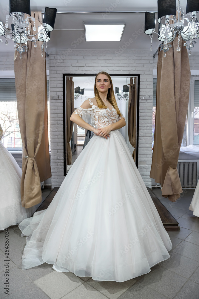 Obraz premium Woman in wedding dress in full length in store