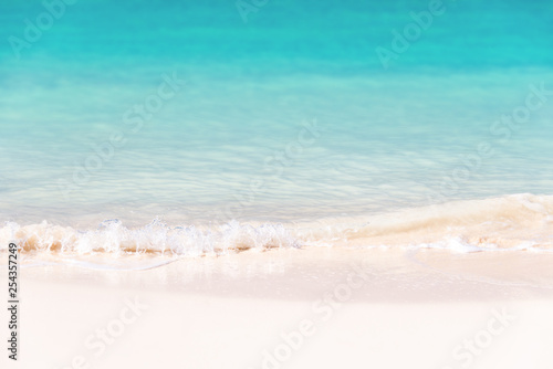 Waves on white sand and turquoise water; summer background