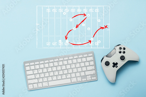 Keyboard and gamepad on a blue background. Doodle drawing with tactics of the game. American football. The concept of computer games, entertainment, gaming, leisure. Flat lay, top view