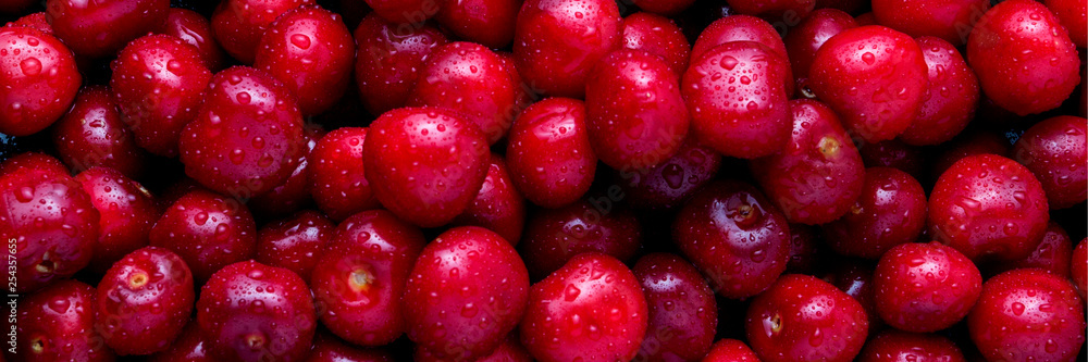 Freshly picked cherries with drops of dew and water. The concept of harvesting. Can be used as a banner, wallpaper, background. Flat lay, top view Freshly picked cherries with drops of dew and water. The concept of harvesting. Can be used as a banner, wallpaper, background. Flat lay, top view