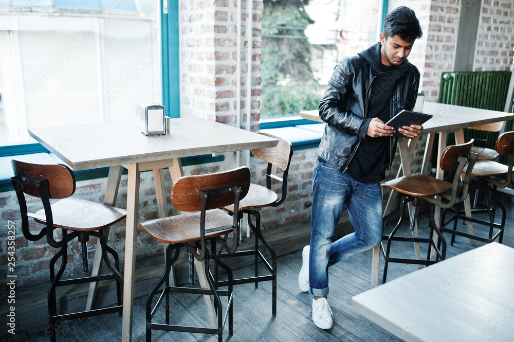Smart young asian man working with tablet during spending time at cafe.