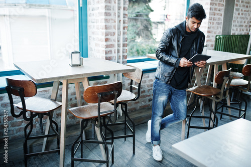 Smart young asian man working with tablet during spending time at cafe.