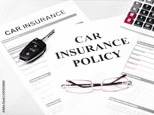 Car insurance policy. Document, car key, glasses and calculator on table. Business and insurance background concept.