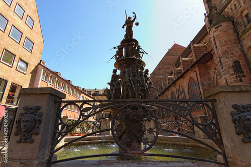 Nuremberg, Germany ? May 07, 2018: Classic wide-angle view of famous Fountain of the Virtues (Tugendbrunnen) in the center of city, late renaissance. Built by Benedict Wurzelbauer from 1584 to 1589