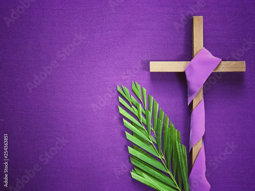 Obraz na plátně Good Friday, Lent Season and Holy Week concept - A religious cross and palm leaves on purple background