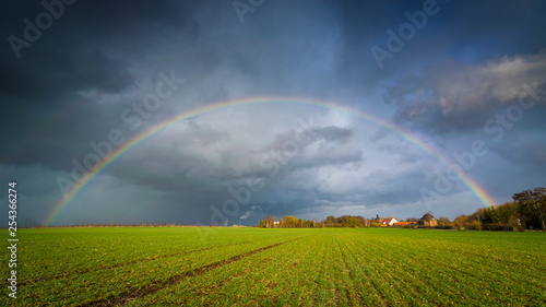 Regenbogen während Sturm Eberhard in Deutschland über einem Feld
