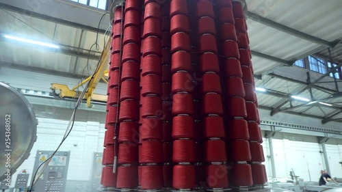 Textile factory female worker works with thread coloring machine. Modern technology in dyeing yarns with Machines for Textile Industry, Dyeing Machine Chemical Tanks