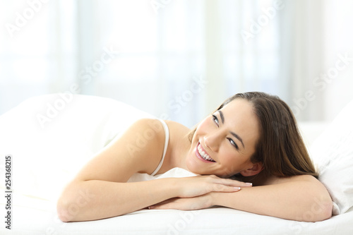 Girl dreaming looking at side on a bed at home