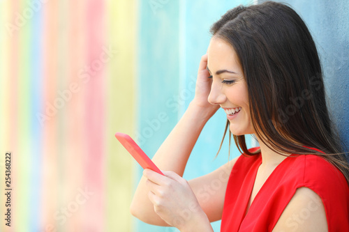 Fashion happy woman checking smart phone outside