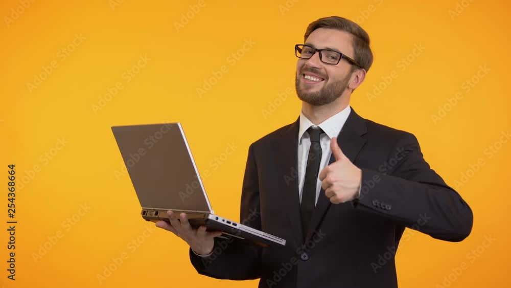 Happy man holding laptop showing thumbs up, satisfied with new software work Happy man holding laptop showing thumbs up, satisfied with new software work