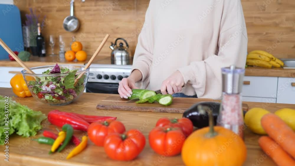 Woman Cutting Fresh Vegetables For Healthy Green Salad In Kitchen. Woman Cutting Fresh Vegetables For Healthy Green Salad In Kitchen.