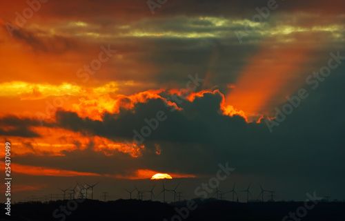 Wind turbine sunrise and dramatic sky in Normandy coast