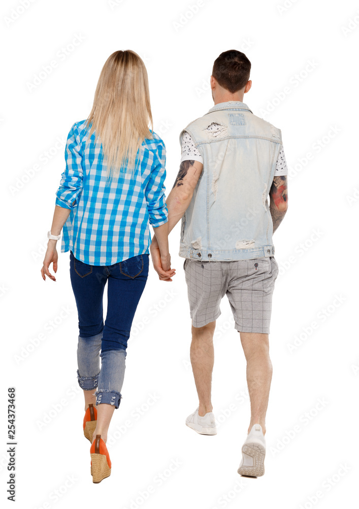 Back view of going couple. walking friendly girl and guy holding hands. Back view of going couple. walking friendly girl and guy holding hands.
