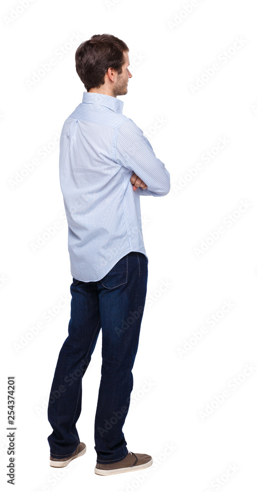 Back view of man in dark jeans. Standing young guy. Back view of man in dark jeans. Standing young guy.