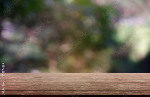 Empty wooden table in front of abstract blurred green of garden and nature light background. For montage product display or design key visual layout - Image