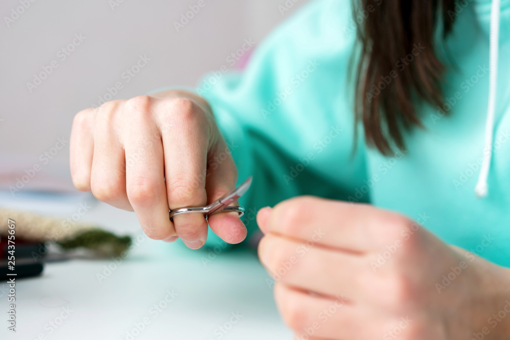teen girl cuts nails with scissors close-up