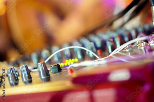 Closeup knobs and button of sound control in colorful lights party on blurry background.