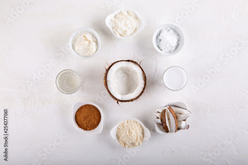 Coconut Products - coconut oil, water, milk, sugar, flakes and flour on white background. Top view.