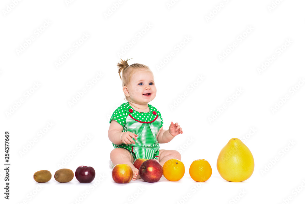 Baby girl sitting with fruits and vegetables, isolated over white Baby girl sitting with fruits and vegetables, isolated over white