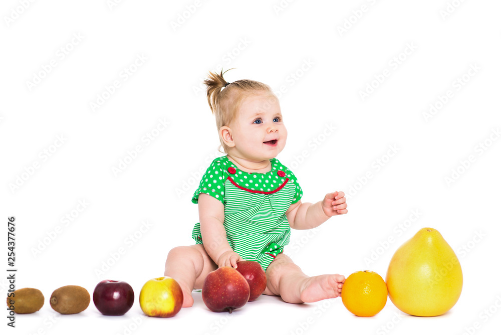 Baby girl sitting with fruits and vegetables, isolated over white Baby girl sitting with fruits and vegetables, isolated over white