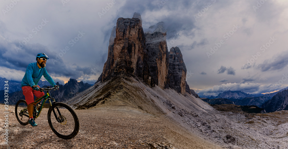 Cycling woman and man riding on bikes in Dolomites mountains andscape. Couple cycling MTB enduro trail track. Outdoor sport activity. Cycling woman and man riding on bikes in Dolomites mountains andscape. Couple cycling MTB enduro trail track. Outdoor sport activity.