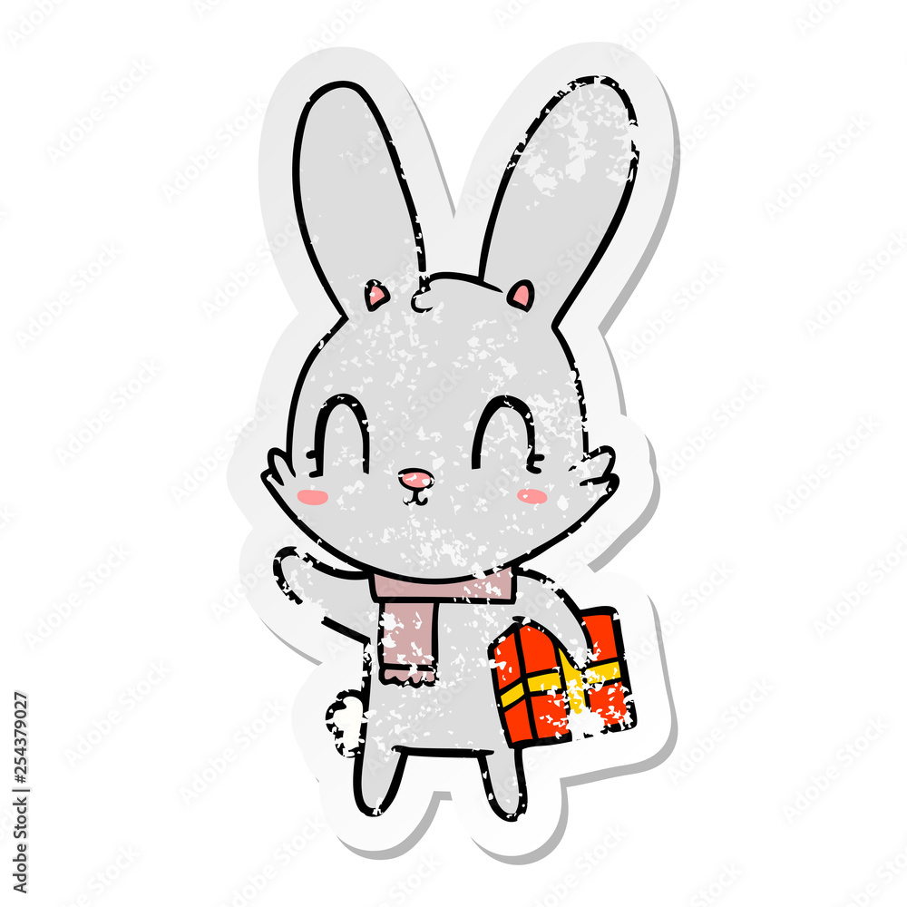 distressed sticker of a cute cartoon rabbit with christmas present distressed sticker of a cute cartoon rabbit with christmas present