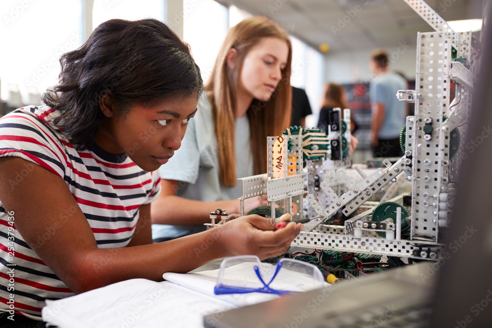 Two Female College Students Building Machine In Science Robotics Or Engineering Class - obrazy, fototapety, plakaty 