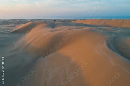 Untouched sand dunes glowing in orange sunrise light. Anna Bay, New South Wales, Australia