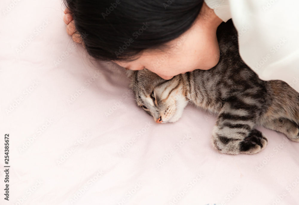 happy cat lovely comfortable sleeping by the woman kissing . love to animals concept .