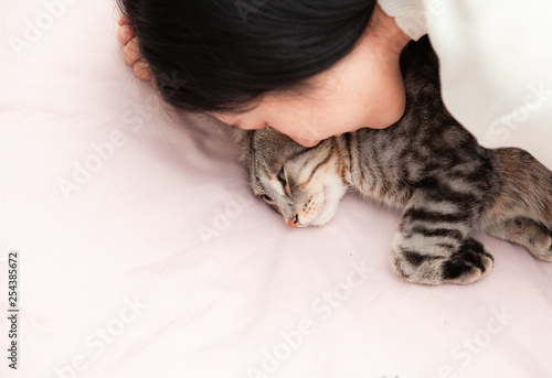 happy cat lovely comfortable sleeping by the woman kissing . love to animals concept .