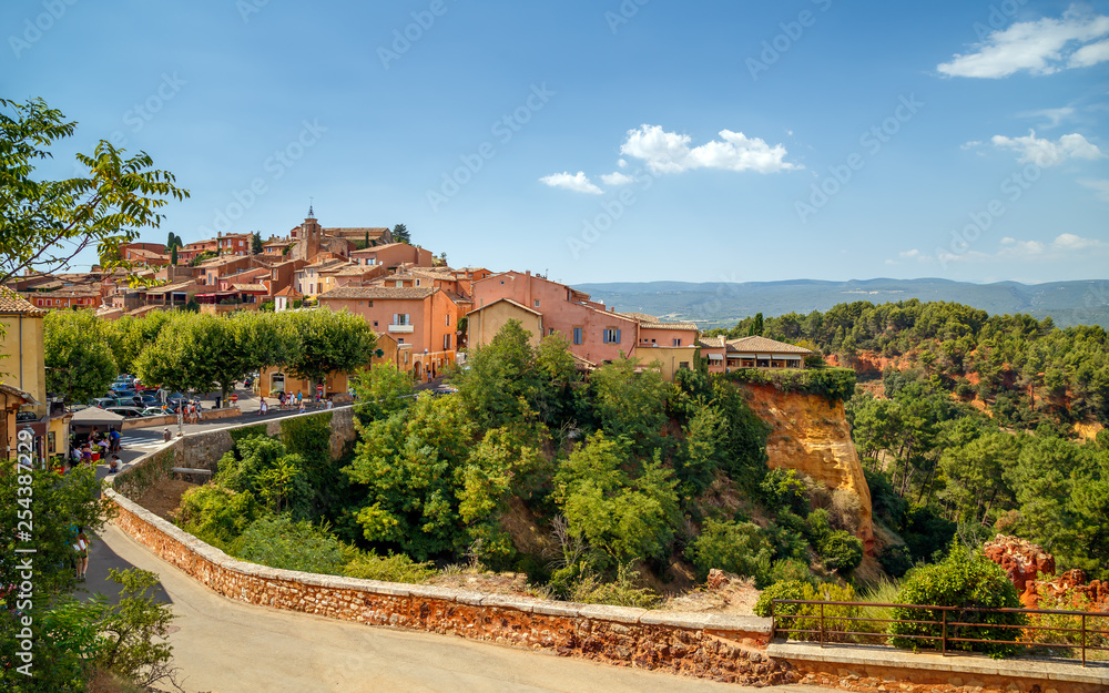 Panoramic view of hilltop medieval ocher village of Roussillon, one of the most beautiful villages of France, in a sunny summer day. Provence, Vaucluse, travel France.