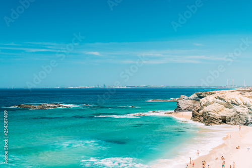 Tourists Having Fun In Water, Relaxing And Sunbathing At Beach In Portugal