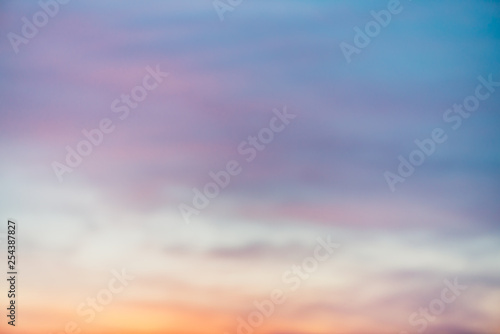 Sunset sky with violet yellow light clouds. Colorful smooth blue sky gradient. Natural background of sunrise. Amazing heaven at morning. Slightly cloudy evening atmosphere. Wonderful weather on dawn. © Daniil