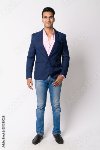Full body shot of happy young Indian businessman in suit smiling © Ranta Images