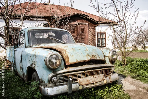 Obraz  z motywem old abandoned retro car in the yard near the house