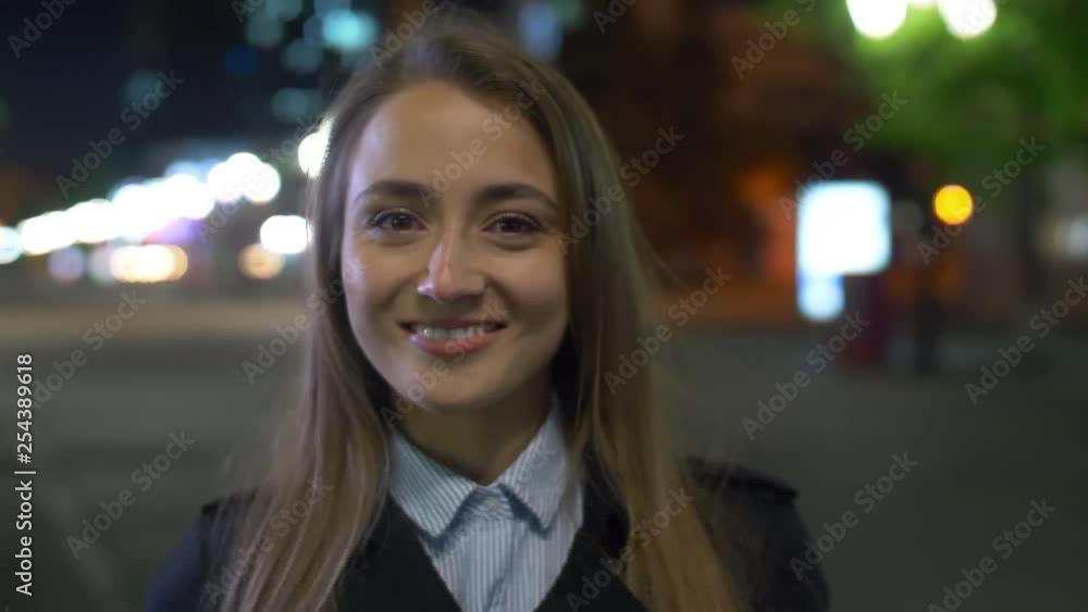 Portrait of young smiling Caucasian businesswoman standing outside in the evening Portrait of young smiling Caucasian businesswoman standing outside in the evening