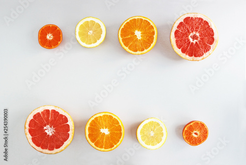 halved citrus fruits  in  a row on gray background