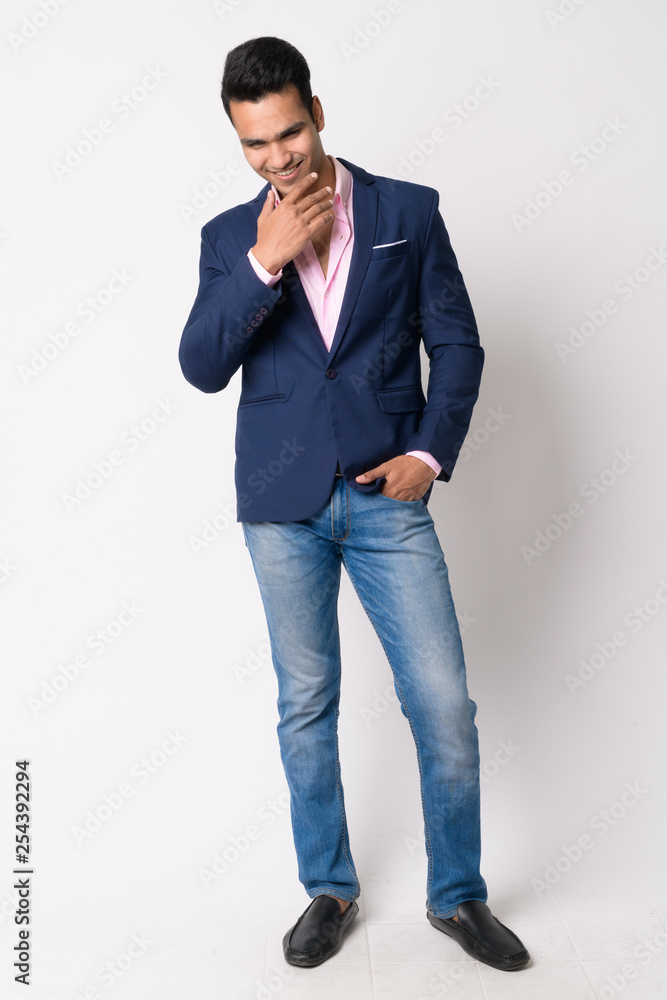 Full body shot of happy young Indian businessman laughing Full body shot of happy young Indian businessman laughing