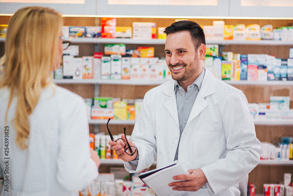 Male pharmacist talking to his female trainee. Male pharmacist talking to his female trainee.
