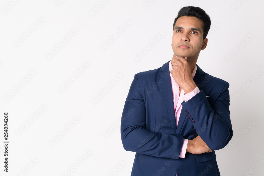Portrait of young handsome Indian businessman in suit thinking Portrait of young handsome Indian businessman in suit thinking