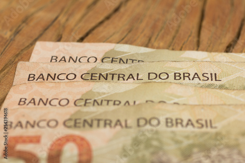 Cash bills from brazilian currency. Close up of cash bills on rustic wood table.