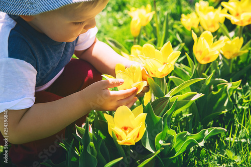 Child with tulips flowers outdoors at springtime
