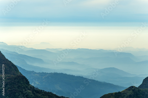 mountain landscape with fog and forest Worlds End in Horton Plains National Park Sri Lanka.