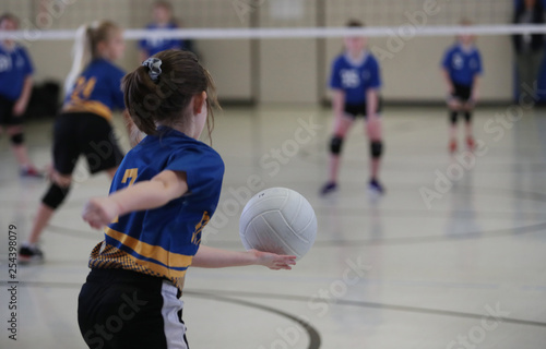 young girls serves a volleyball photo