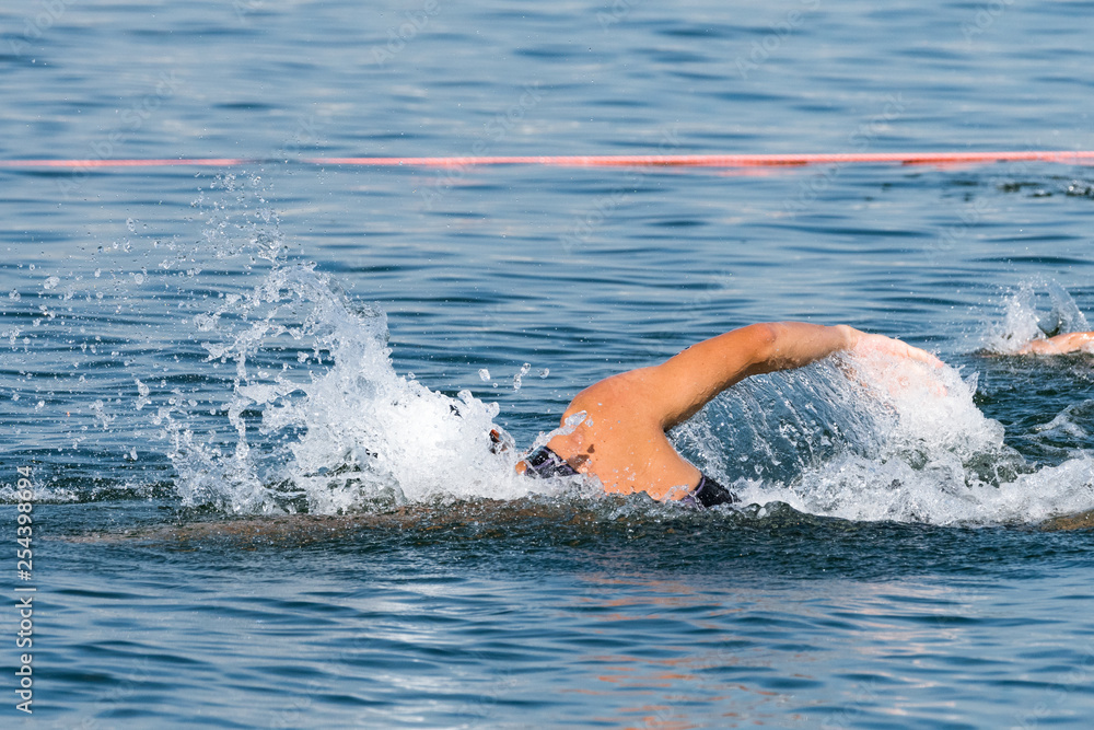 トライアスロン大会スイム競技中に美しいフォームで泳ぐ選手